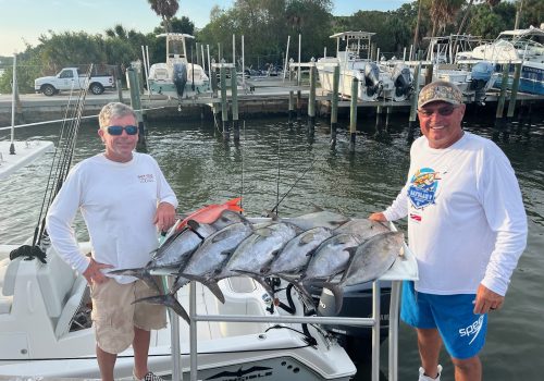 Happy fishermen standing near their fish caught during Inshore Fishing in Tampa Bay FL