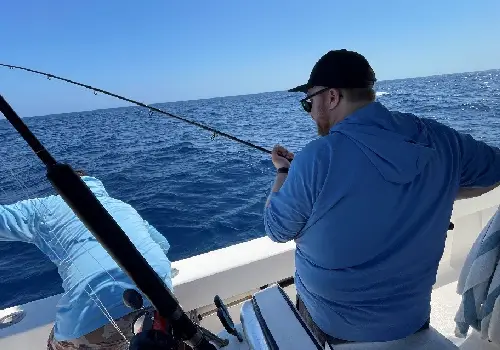 Happy fisherperson reeling in a fish with help from expert Fishing Charters in Clearwater Beach & St. Petersburg FL