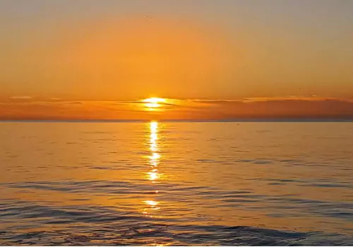The sun setting on the water during Sunset Cruises with Tradewinds Fishing Charters
