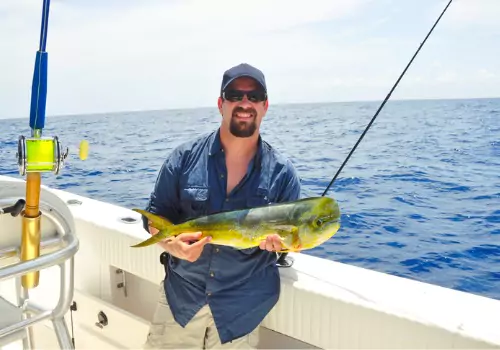 A guest from Tradewinds Fishing Charters, one of the Best Fishing Charters in St. Petersburg FL, holds a fish he caught on his trip