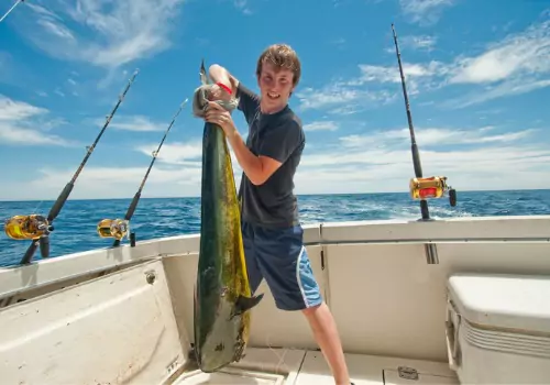 A teenager holds up a fish he caught while on a trip with Tradewinds Fishing Charters, one of the Best Fishing Charters in Tampa Bay FL