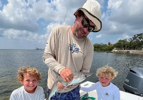 Dad standing with kids after catching fish during Inshore Fishing in Clearwater FL