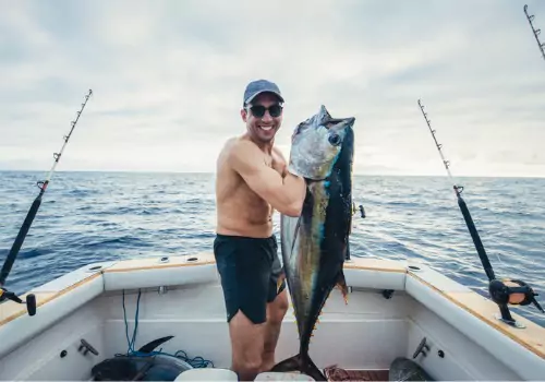 A man holds a fish he caught during one of the Fishing Trips in Anna Maria FL that Tradewinds Fishing Charters offers