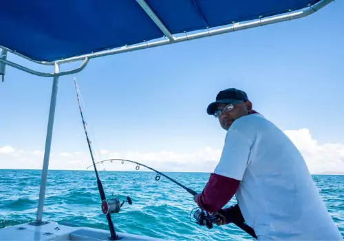 A man reels in a catch while on the water with Tradewinds Fishing Charters' Captain Patrick, one of the Best Fishing Captains Clearwater FL has to offer